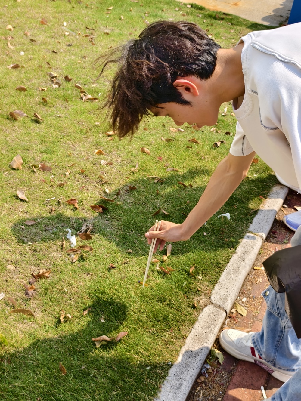 学生们在校园内开展垃圾清理劳动实践场景